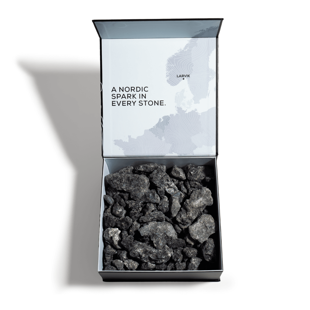 Open box containing dark gray stone fragments with a map of Northern Europe on the lid and the textA Nordic spark in every stone.