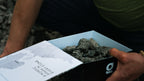 Hands holding the opened glør Larvikite stone box at the quarry in Larvik, Norway